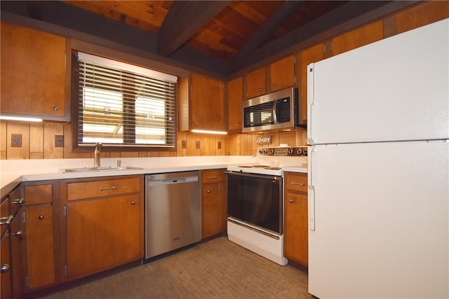 kitchen with sink, wooden ceiling, lofted ceiling with beams, wood walls, and appliances with stainless steel finishes