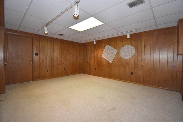 basement with light colored carpet and wood walls