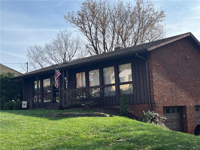 view of side of property with a yard and a garage