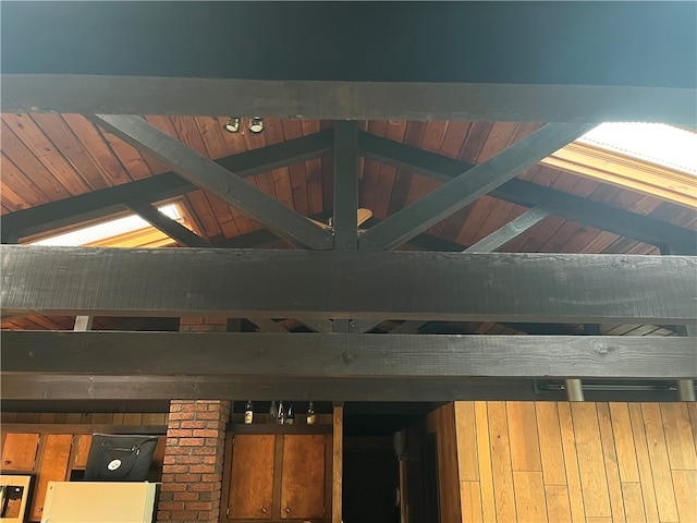 room details featuring wood walls and beam ceiling