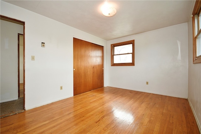 unfurnished bedroom with a closet and light hardwood / wood-style flooring