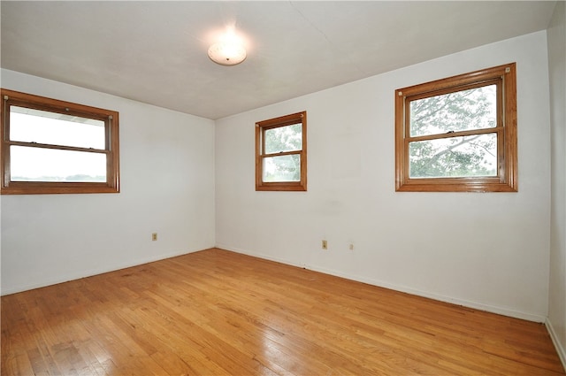 unfurnished room featuring light wood-type flooring and plenty of natural light