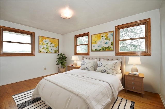 bedroom with light hardwood / wood-style flooring and multiple windows