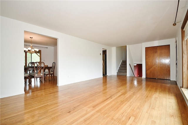 spare room featuring a notable chandelier and wood-type flooring