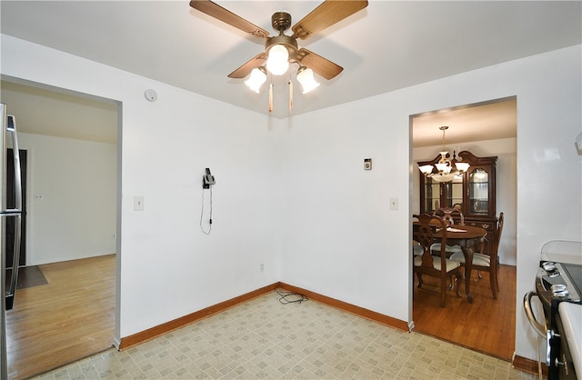 unfurnished room with ceiling fan with notable chandelier and light wood-type flooring