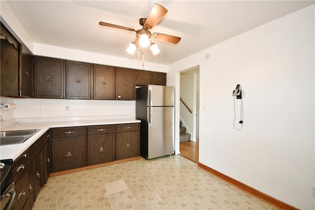 kitchen with dark brown cabinets, ceiling fan, sink, and stainless steel appliances