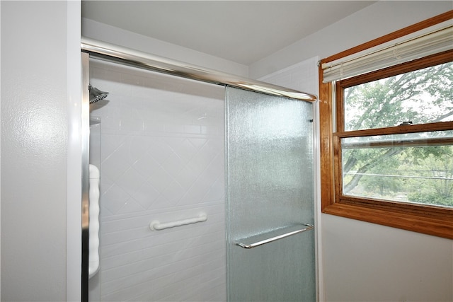 bathroom with a shower with door