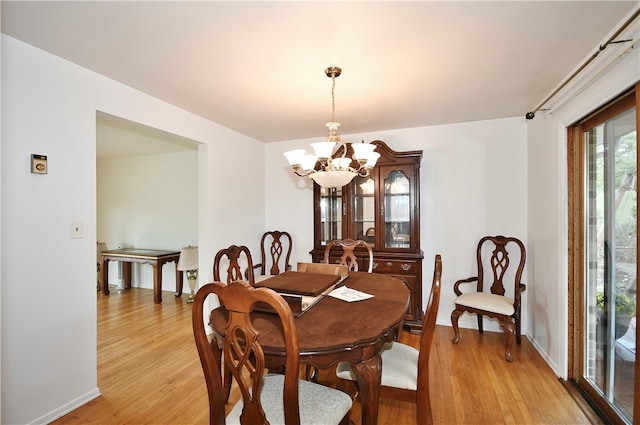 dining room featuring light wood-type flooring and an inviting chandelier