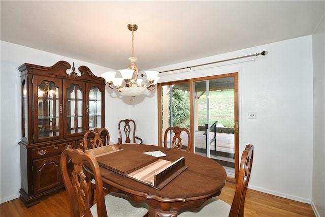 dining area with wood-type flooring and a chandelier