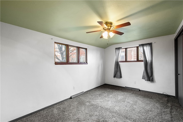 empty room featuring ceiling fan, carpet floors, and vaulted ceiling