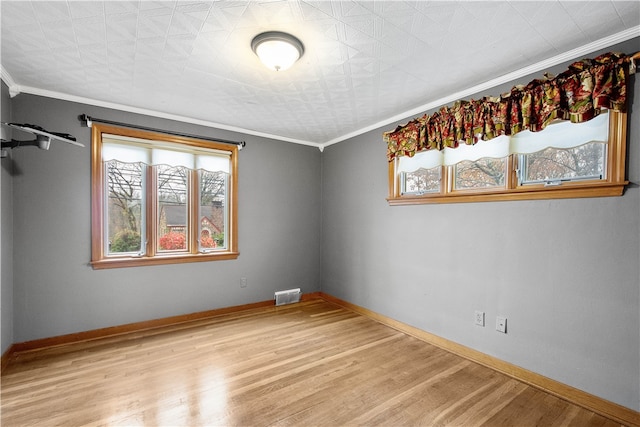 empty room featuring crown molding and light hardwood / wood-style flooring