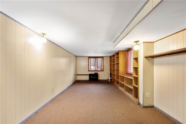 spare room with carpet flooring and wood walls