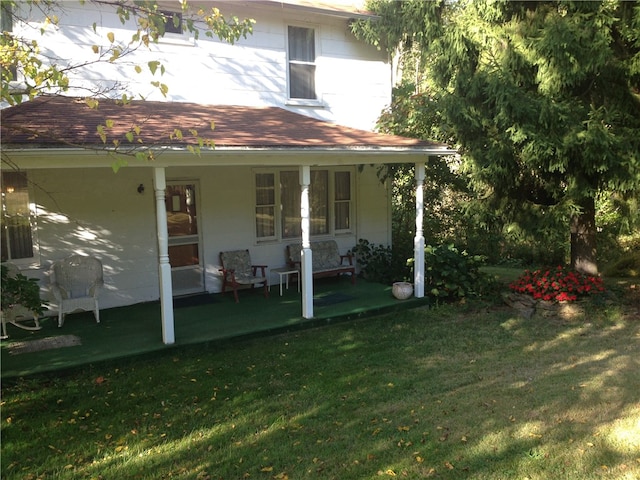 back of house featuring a yard and a porch