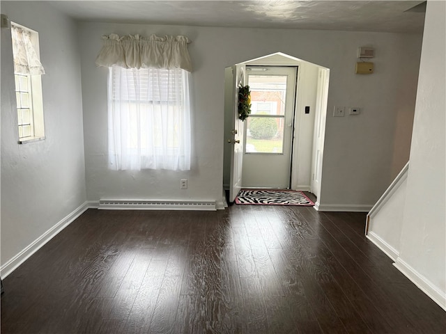 interior space featuring dark wood-type flooring and a baseboard heating unit