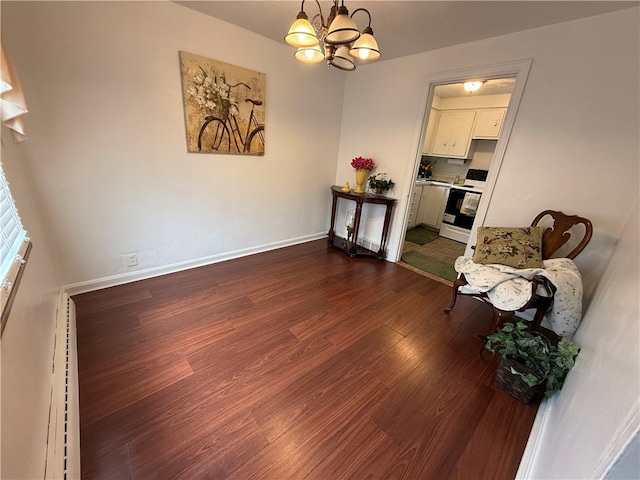 sitting room featuring dark wood-type flooring and a notable chandelier