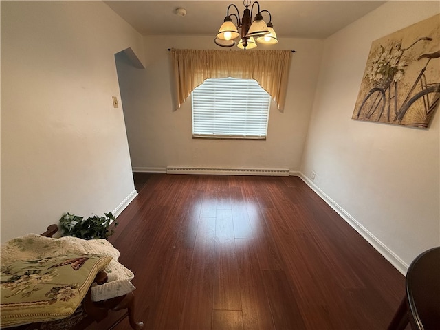 dining area featuring dark hardwood / wood-style floors, baseboard heating, and a notable chandelier