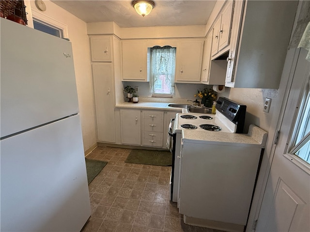 kitchen with white cabinets, white appliances, and sink