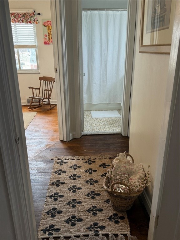 corridor with hardwood / wood-style flooring