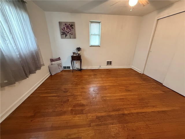 empty room with dark hardwood / wood-style floors and ceiling fan