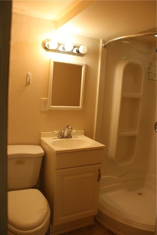 bathroom featuring vanity, toilet, and walk in shower