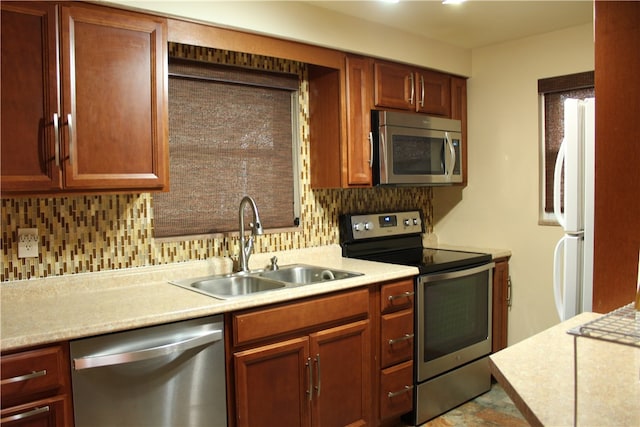 kitchen with appliances with stainless steel finishes, tasteful backsplash, and sink