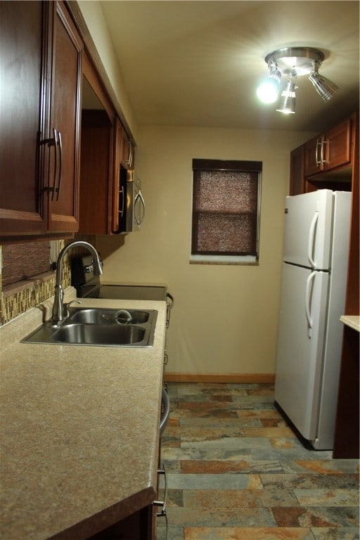 kitchen with white refrigerator, sink, and tasteful backsplash