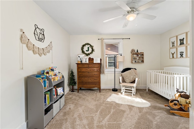 bedroom with carpet flooring, ceiling fan, and a crib