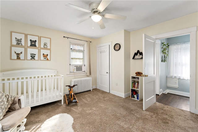 bedroom featuring ceiling fan, radiator heating unit, carpet, and a nursery area