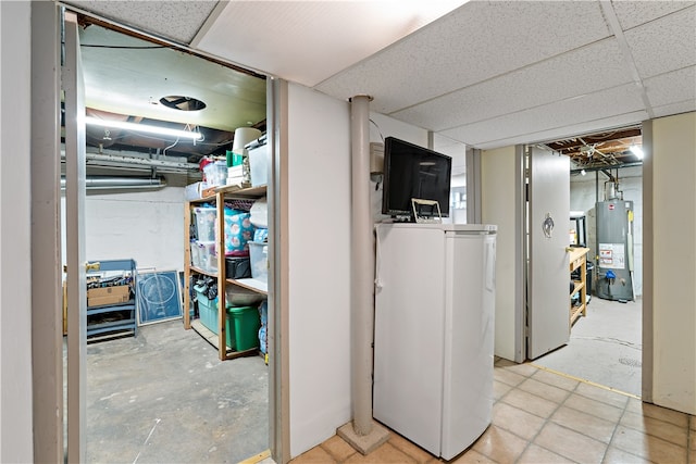 basement featuring a paneled ceiling and water heater