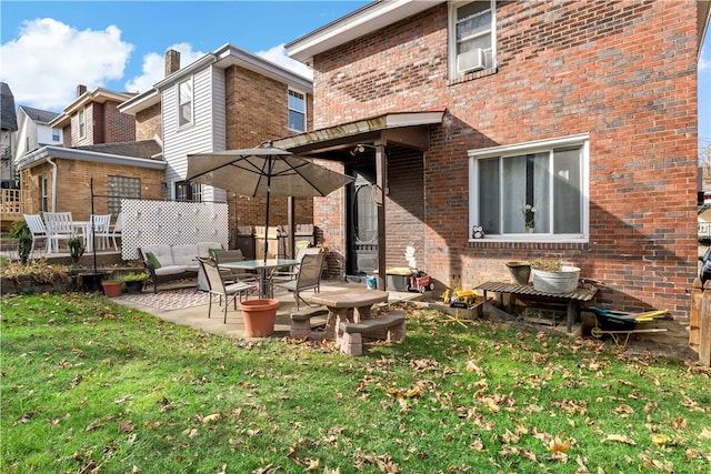 rear view of property featuring a yard, a patio, and cooling unit