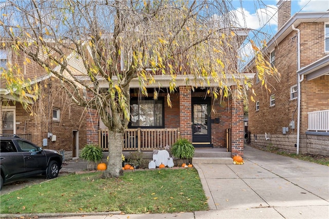 view of front of home featuring covered porch and a front yard