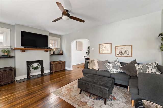 living room with ceiling fan and dark wood-type flooring