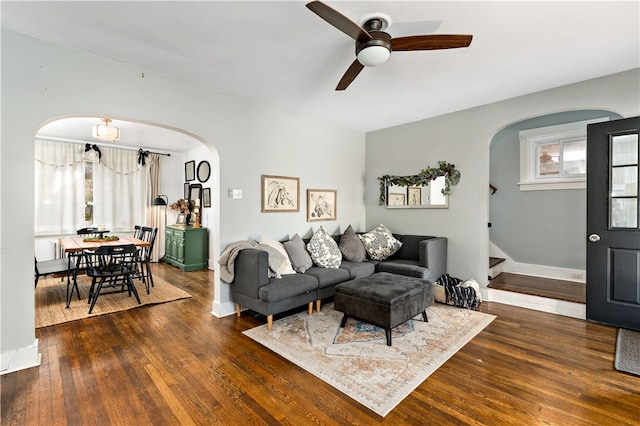 living room featuring plenty of natural light, ceiling fan, and dark wood-type flooring