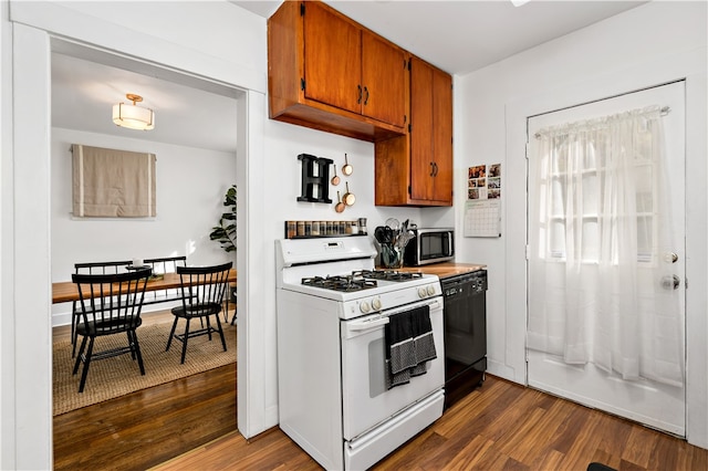 kitchen with gas range gas stove, dark wood-type flooring, and black dishwasher