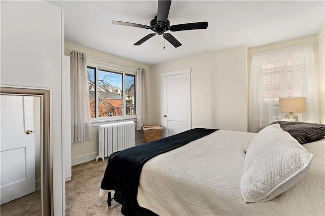 carpeted bedroom with radiator and ceiling fan