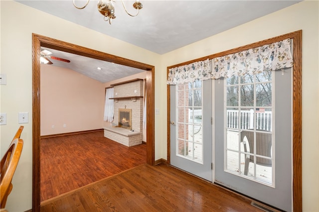 interior space with a fireplace, wood-type flooring, ceiling fan, and lofted ceiling