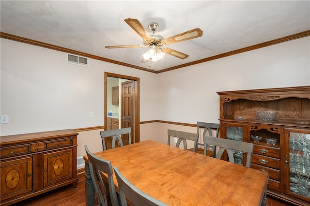 dining space with crown molding, ceiling fan, and dark wood-type flooring