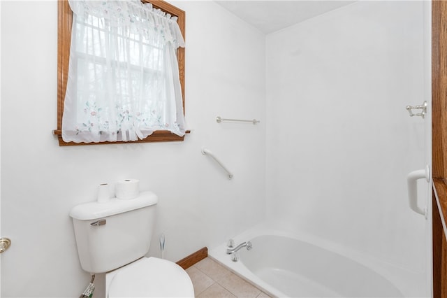 bathroom with tile patterned floors, a washtub, and toilet