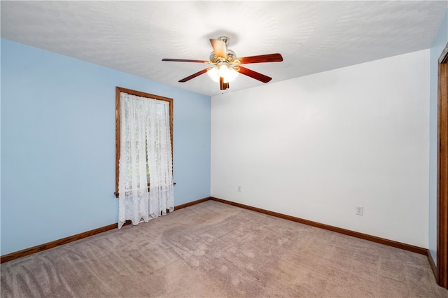 empty room featuring ceiling fan and light carpet