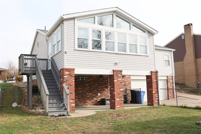 rear view of house featuring a garage and a lawn