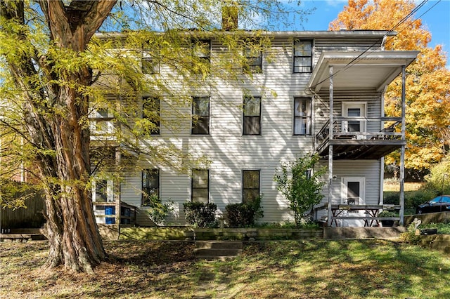 back of house featuring a yard and a balcony