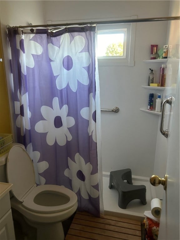 bathroom with a shower with shower curtain, vanity, and toilet