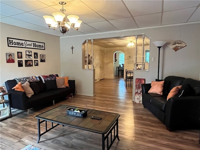 living room with a paneled ceiling, wood-type flooring, and an inviting chandelier