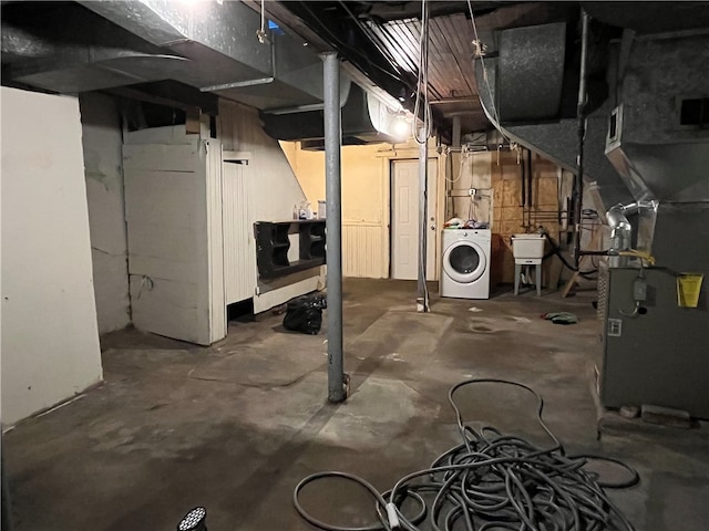 basement featuring washer / dryer, sink, and heating unit