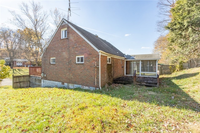 view of side of home featuring a yard and a sunroom