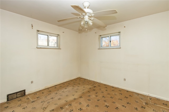 carpeted spare room with plenty of natural light and ceiling fan