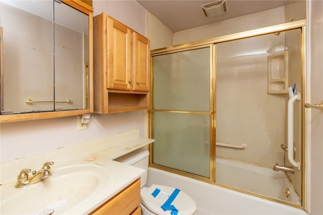 full bathroom featuring toilet, combined bath / shower with glass door, and vanity