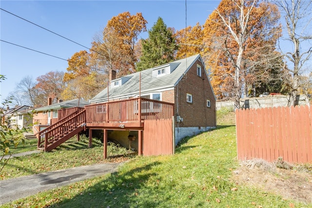 back of house featuring a lawn and a wooden deck