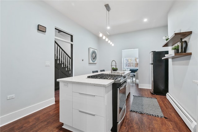 kitchen featuring dark hardwood / wood-style flooring, stainless steel appliances, baseboard heating, white cabinetry, and hanging light fixtures