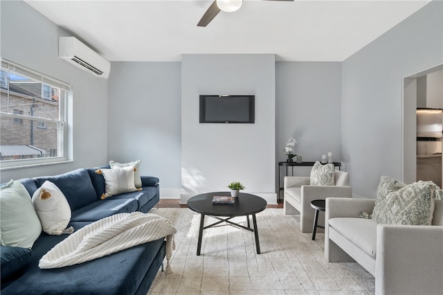 living room featuring ceiling fan, a wall unit AC, and light hardwood / wood-style flooring